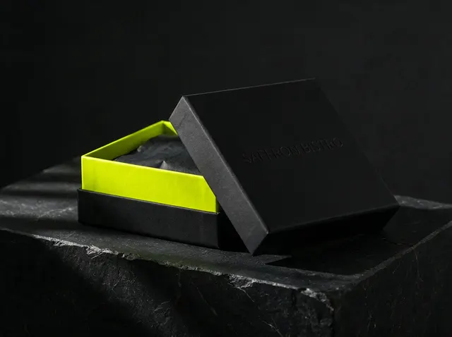 Illustrative mockup: a rigid black box with its lid lifted off