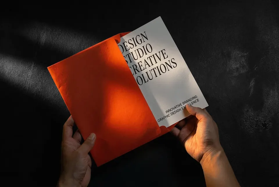 Illustrative mockup: an orange brochure held open